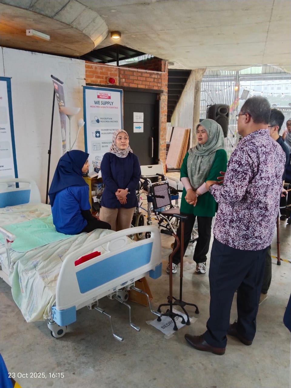National Pharmacy team discussing home recovery equipment with visitors